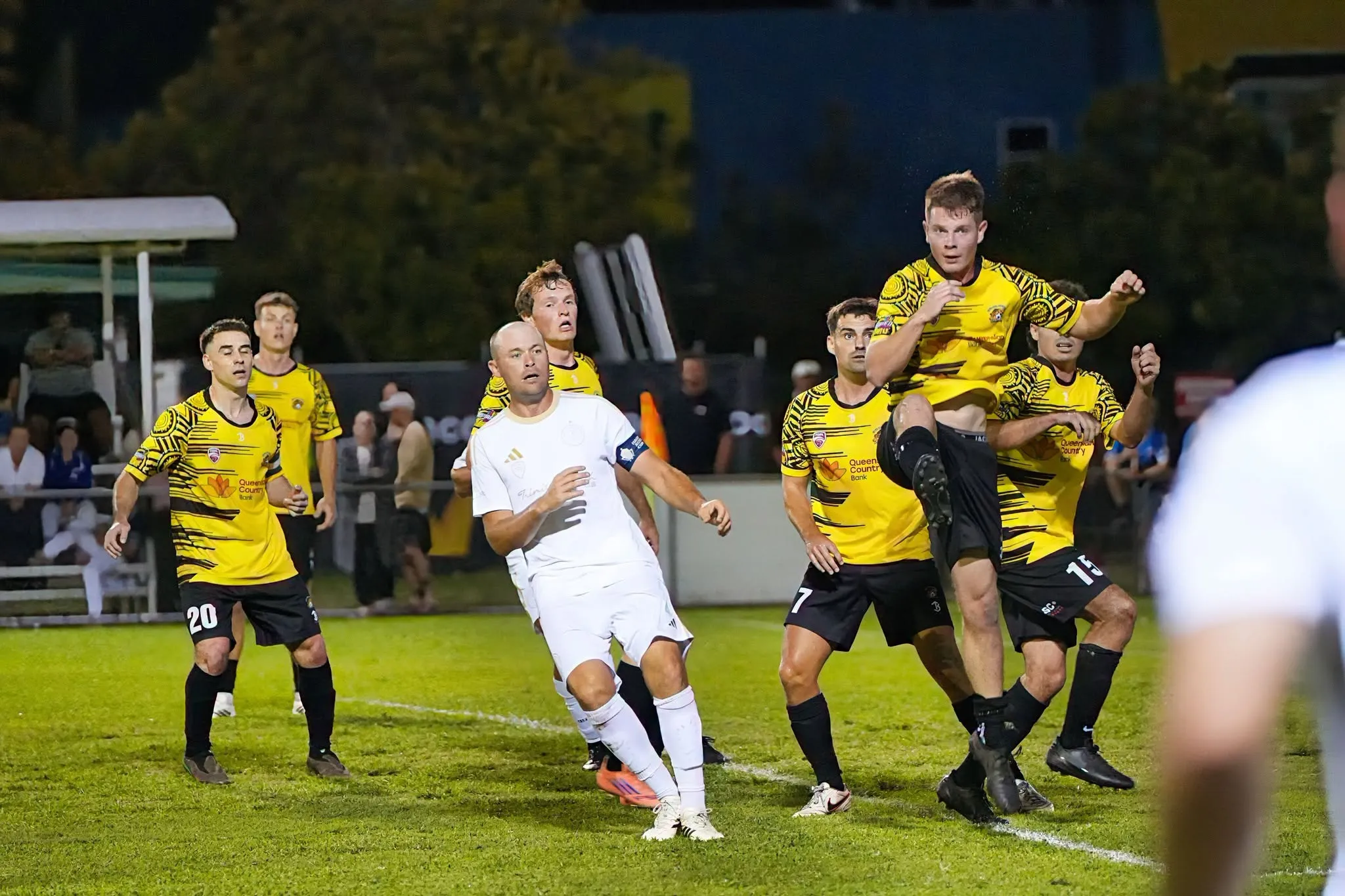A Marlin Coast Rangers senior player surrounded by opponents as a cross comes into the box